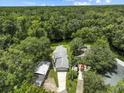 Aerial view of the property showcasing the house, lush green surroundings, and waterfront location at 6090 Waverly Rd, Weeki Wachee, FL 34607
