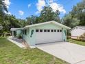 Charming exterior of the home featuring a spacious two-car garage and seahorse accents at 6090 Waverly Rd, Weeki Wachee, FL 34607
