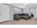 Inviting living room with tile flooring and a comfortable grey leather sectional at 7037 Green St, New Port Richey, FL 34652