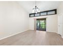 Bright living room featuring high ceilings, contemporary light fixture and sliding glass doors at 7650 Forest Trl # 7, Port Richey, FL 34668
