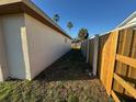 View of side yard with light colored exterior and a newly constructed wooden fence at 8607 Longboat Ln, Hudson, FL 34667