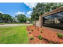 Welcoming Timber Greens community entrance with brick signage, lush landscaping and a scenic view at 9634 Green Needle Dr, New Port Richey, FL 34655