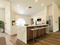Modern kitchen with a marble-topped island, stainless steel appliances, and sleek bar stool seating at 1032 Concert Ave, Spring Hill, FL 34609