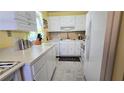 Cozy kitchen featuring white cabinets and appliances, perfect for cooking at 11817 Bayonet Ln, New Port Richey, FL 34654