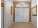 Warm and inviting foyer with double doors and tile flooring at 13140 Maycrest Ave, Weeki Wachee, FL 34614