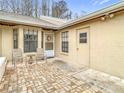 Cozy brick-paved patio with seating area, enclosed by white walls offering privacy and charm in this home at 13227 Molitor Ct, Hudson, FL 34669
