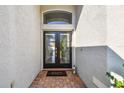 Inviting front entryway with double doors, transom window and 'welcome home' doormat at 215 Arbor Woods Cir, Oldsmar, FL 34677