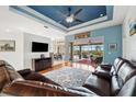 Bright living room with stylish ceiling, wood floors, and view of the outdoor pool at 2336 Edelweiss Loop, Trinity, FL 34655