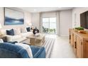 Bright living room features a plush white sofa, lake view, stylish decor, and sliding glass doors to the patio at 285 Voltaire Dr, Spring Hill, FL 34609