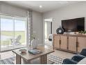 Living room includes a water view through sliding glass doors, a sleek entertainment center and comfy seating at 285 Voltaire Dr, Spring Hill, FL 34609