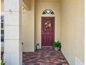 Welcoming entryway features a red door adorned with a wreath and decorative accents at 3042 Gianna Way, Land O Lakes, FL 34638