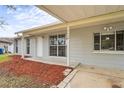 Exterior front view with a grey facade, carport, and tidy landscaping at 3209 Kismet Ct, New Port Richey, FL 34655