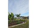 Front yard showcasing lush garden bed with diverse plantings and manicured lawn at 36312 Toranado Way, Zephyrhills, FL 33541