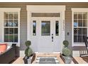 Elegant front door with glass accents, decorative plants, and a 'Welcome' mat for a warm entry at 3733 Wiregrass Rd, New Port Richey, FL 34655
