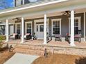 Inviting front porch with brick accents, stylish seating, and ceiling fans for added comfort at 3733 Wiregrass Rd, New Port Richey, FL 34655