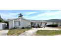 Single-story home with stone facade, attached garage, and manicured landscaping at 4030 Grayton Dr, New Port Richey, FL 34652