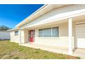 Charming single-story home featuring a red front door and classic architectural features at 4938 Fruitwood Loop, Holiday, FL 34690