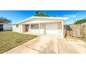 Charming single-story home with garage, and an extended driveway leading to the garage at 4938 Fruitwood Loop, Holiday, FL 34690
