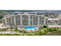 Beautiful condo building featuring a pool with surrounding lounge chairs and landscaped greenery at 5915 Sea Ranch Dr # 211, Hudson, FL 34667