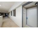 Condo 408 sits at the end of a long hallway with tile floors and muted white walls at 6035 Sea Ranch Dr # 408, Hudson, FL 34667