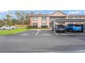 Condo building with guest and resident parking, manicured lawn and shrubs, and covered parking spaces at 6440 Spring Flower Dr # 11, New Port Richey, FL 34653