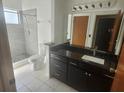 Bathroom showcasing granite countertops, a tiled walk-in shower, and modern fixtures at 7125 Silverwood Dr, New Port Richey, FL 34654