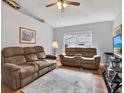 Comfortable living room showcasing two sofas, a ceiling fan, and bright natural light at 7205 Pinehurst Dr, Spring Hill, FL 34606