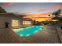 Inviting pool area with brick patio, poolside seating, and stunning sunset views at 7901 Willow Brook Ct, Hudson, FL 34667