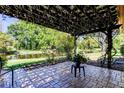 Relaxing back porch with a pergola overlooking a peaceful pond and verdant backyard at 9925 Whitworth Ct, New Port Richey, FL 34655