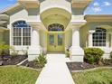 Inviting front entrance with double doors, decorative columns and elegant archway at 10285 Velvetseed Cir, Spring Hill, FL 34608