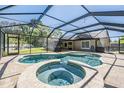 Enclosed pool area with a large screened-in pool, attached spa, and plenty of room for outdoor entertaining at 12215 Snead Pl, Tampa, FL 33624
