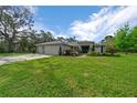 Charming single-story home featuring a manicured lawn and a three-car garage, blending comfort and convenience at 16386 Heron Hills Dr, Spring Hill, FL 34610