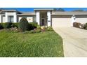 Charming one-story home featuring a lush green lawn and manicured landscaping at 18045 Tarrington Pl, Hudson, FL 34667