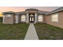 Stunning single-story home exterior featuring a grand entrance with columns and a well-manicured lawn at 18317 Treehaven Dr, Hudson, FL 34667