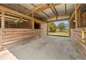 Barn interior view showcasing wooden stalls and a concrete floor, providing a secure and functional space at 28089 Old Trilby Rd, Brooksville, FL 34602