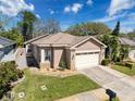Charming single-Gathering home with a front lawn, two-car garage, and brick-accented facade under a sunny sky at 3555 Sylvan Edge Dr, Palm Harbor, FL 34685