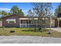 Charming single-story home featuring brown siding, a cozy front porch, and a well-maintained lawn at 3728 Linkwood St, New Port Richey, FL 34652