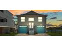 Two-story home featuring a two-car garage with blue doors, well-maintained front yard and a sunset at 4046 Casa Ct, Hernando Beach, FL 34607
