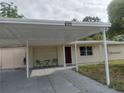 Inviting single-story home with a covered carport, cozy chairs, and a well-manicured lawn at 4743 Foothill Dr, Holiday, FL 34690