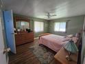 Cozy bedroom with wood floors, natural light, and ample dresser storage at 5211 Wisteria Cir, New Port Richey, FL 34653