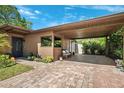 Inviting carport with brick flooring, a cozy seating area, and lush landscaping at 6433 Murray Hill Dr, Tampa, FL 33615