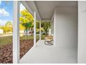 Inviting front porch with white columns and cozy wicker chairs for relaxing outdoors at 6514 Grapewood Rd, Spring Hill, FL 34609