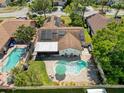 Aerial view of the property with a pool, solar panels, and fenced yard at 7215 121St Ter, Largo, FL 33773