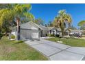 Charming single-story home features a well-manicured lawn, attractive landscaping, and a patterned concrete driveway at 7305 Sugarbush, Spring Hill, FL 34606