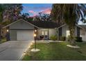 Charming single-story home boasts a well-manicured lawn, beautiful landscaping, and a welcoming facade at sunset at 7305 Sugarbush, Spring Hill, FL 34606
