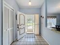Inviting foyer with tile flooring and decorated front door with view to the outside at 8367 Apple Orchard Rd, Spring Hill, FL 34608