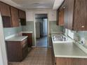 Kitchen features original cabinetry, tile backsplash, a stainless sink and views to the backyard at 10803 Hachita Dr, Port Richey, FL 34668