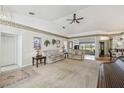 Bright living room features neutral carpet, a ceiling fan, and leads to a dining area at 11231 Sun Tree Rd, Hudson, FL 34667