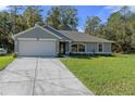 Charming single-story home featuring a well-maintained lawn, attached two-car garage, and freshly painted exterior at 11388 Paramount Ave, Weeki Wachee, FL 34614