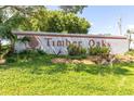 Timber Oaks community sign set amongst lush green landscaping on a bright, sunny day at 11526 Forest Run Ct, Port Richey, FL 34668